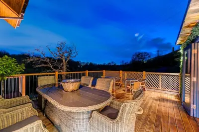 a patio with a table and chairs on a deck at Luxury Lodge 18 by Ashgrove Leisure in Moffat