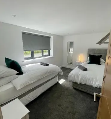 a bedroom with two beds and a window at Luxury Lodge 18 by Ashgrove Leisure in Moffat