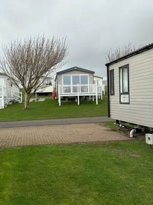 a mobile home with a bench and a house at Paws a while in Mainsriddle