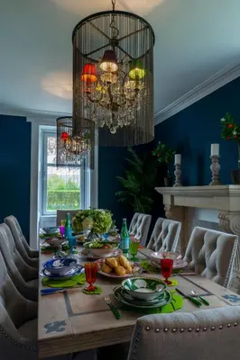 a dining room with a table with food and a chandelier at The Painted Cow in Beattock