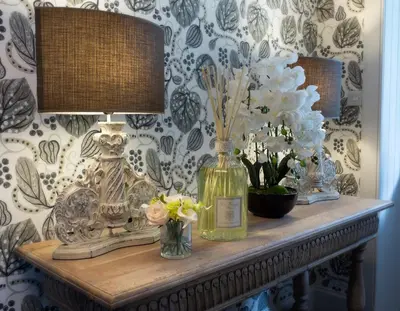 a table with a lamp and flowers on it at The Painted Cow in Beattock