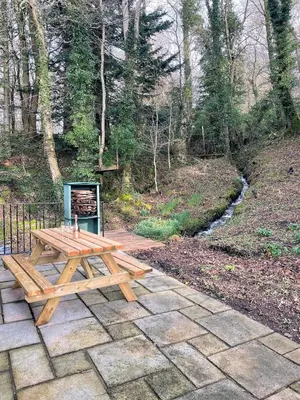 a wooden picnic table sitting on a stone patio at Outstanding Converted Mill in Beautiful Location - Pass the Keys in Gatehouse of Fleet