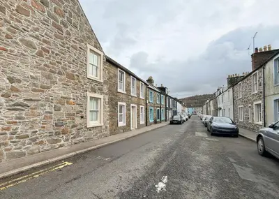 an empty street with cars parked on the side of a building at Beautifully Presented Cosy Home in Kirkcudbright - Pass the Keys in Kirkcudbright
