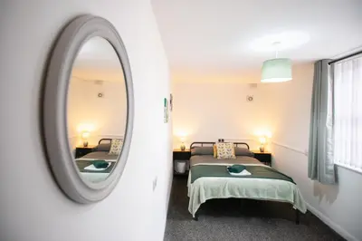 a bedroom with two beds and a mirror at Newton Flat in Carlisle