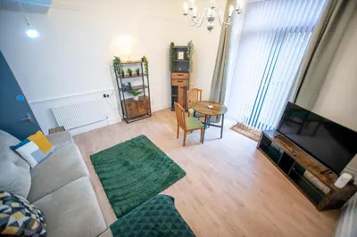 a living room with a couch and a tv and a table at Newton Flat in Carlisle