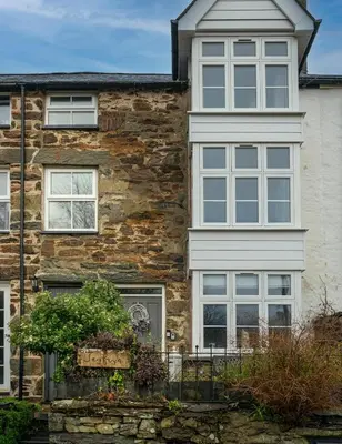 a stone house with windows and plants in front of it at Tegfryn in Moffat