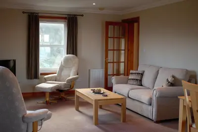 a living room with a couch and a table at Corsewall Lighthouse Hotel in Kirkcolm