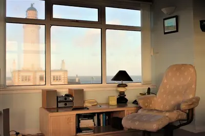 a room with a chair and a desk and a window at Corsewall Lighthouse Hotel in Kirkcolm
