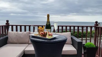 a table with a plate of food and a bottle of champagne at Mount Stewart Hotel in Portpatrick