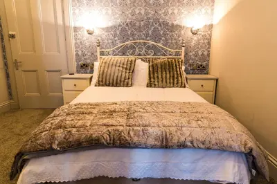 a bedroom with a large bed with two night stands at Mount Stewart Hotel in Portpatrick
