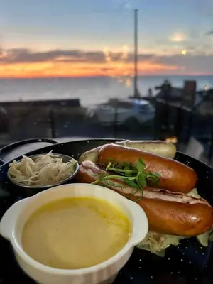 a plate with two hot dogs and a bowl of soup at Mount Stewart Hotel in Portpatrick