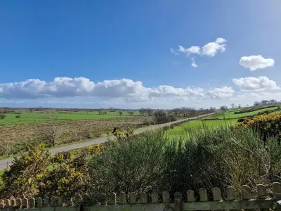a view of a country road in a field at Bankswood Cottage in Ruthwell