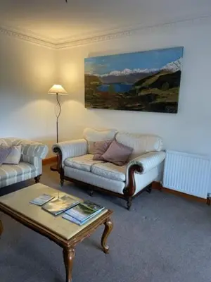 a living room with two couches and a coffee table at Airds Farm Guest House in Castle Douglas