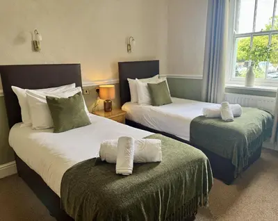a hotel room with two beds with towels at The Manor in St Bees