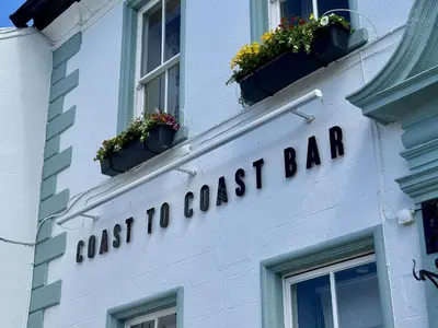 a sign for a coast guest bar on a building at The Manor in St Bees