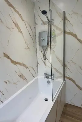a bathroom with a shower with a white tub at The Manor in St Bees