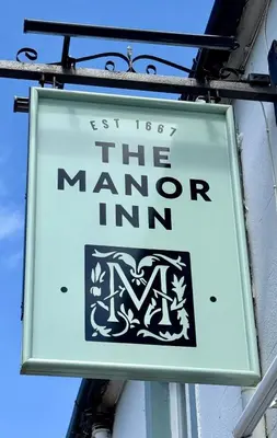 a sign for the manor inn on the side of a building at The Manor in St Bees