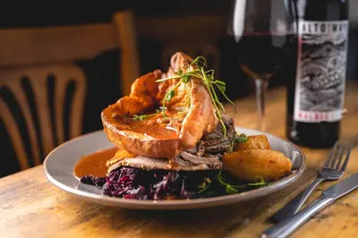 a plate of food on a table with a glass of wine at The Manor in St Bees