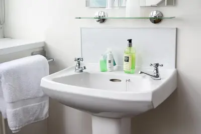 a white bathroom with a sink and a mirror at Skiddaw Croft Bed & Breakfast in Keswick