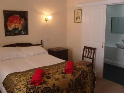 a bedroom with a bed with red pillows on it at Telford Manor House in Beattock