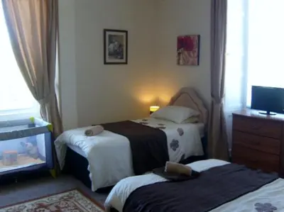 a hotel room with two beds and a television at Telford Manor House in Beattock
