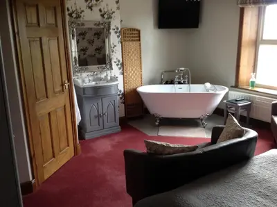 a large bathroom with a tub and a sink at Midtown Farm Bed & Breakfast in Easton