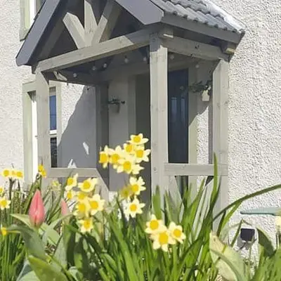 a window with flowers in front of a house at Midtown Farm Bed & Breakfast in Easton