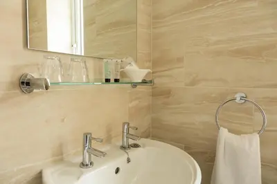 a bathroom with a sink and a mirror at Hermiston Guest House in Keswick