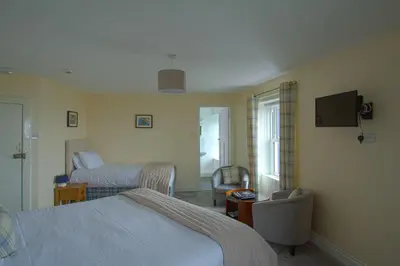 a hotel room with two beds and a tv at The Harbour Inn in Garlieston
