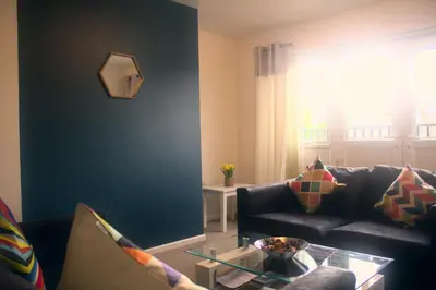 a living room with a couch and a glass table at The Sawmills, Carlisle - Spacious 4 Bedroom Family House - Free WiFi - & Parking - Walk to Carlisle Castle in Carlisle