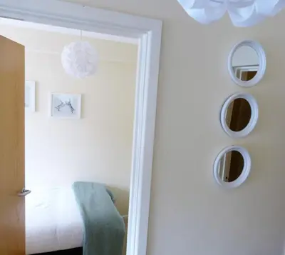 a bedroom with mirrors on the wall and a bed at The Sawmills, Carlisle - Spacious 4 Bedroom Family House - Free WiFi - & Parking - Walk to Carlisle Castle in Carlisle