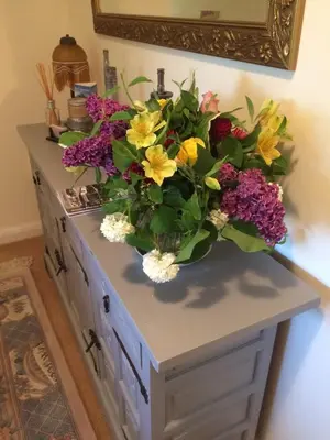 a bouquet of flowers sitting on top of a dresser at Ballacowell in Sulby