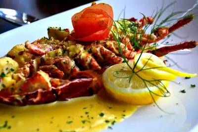 a plate of food with shrimp and a lemon at Crown hotel in Portpatrick