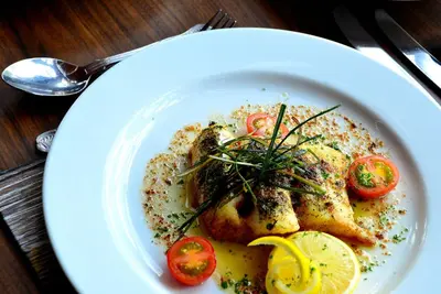 a plate of food with chicken and tomatoes on a table at Crown hotel in Portpatrick