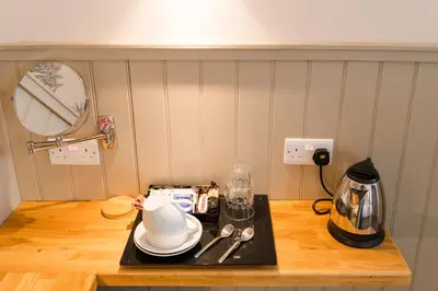 a kitchen counter with a tray with dishes and a kettle at The Harbour Guest House in Irvine