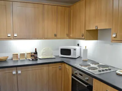 a kitchen with a microwave and a stove top oven at Hearthstanes Steading in Polmood