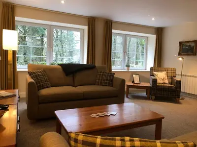 a living room with a couch and a coffee table at Hearthstanes Steading in Polmood