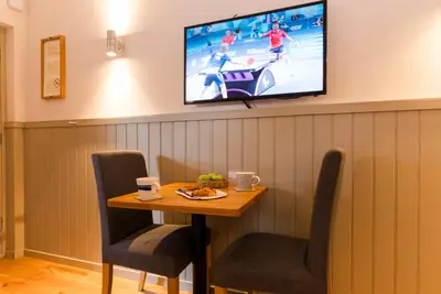 a table with chairs and a tv on a wall at Irvine Bay in Irvine