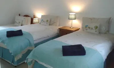 a bedroom with two beds with blue and white at Beech House in Greystoke