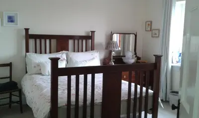 a bedroom with a wooden bed and a mirror at Beech House in Greystoke