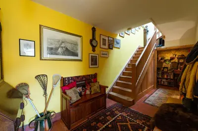 a living room with a staircase and a yellow wall at Beech House in Greystoke
