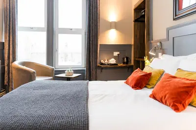 a bedroom with a large white bed with orange pillows at Irvine Guest House in Irvine