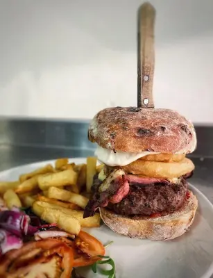 a hamburger and french fries on a white plate at Bower House Inn in Eskdale