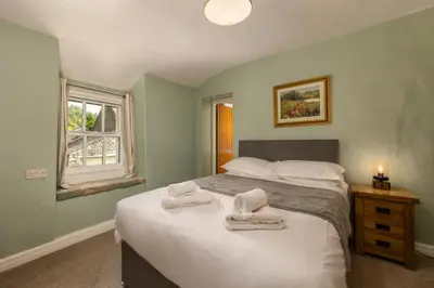 a bedroom with a bed with towels on it at Bower House Inn in Eskdale