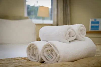 a pile of towels sitting on top of a bed at Stanley House in Eskdale