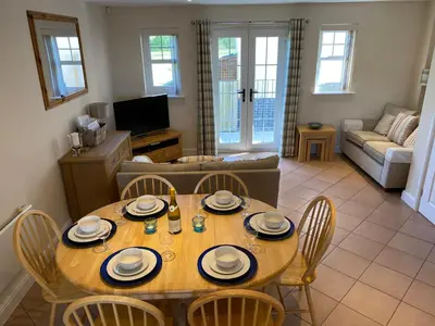 a living room with a wooden table and chairs at Cladach in Garlieston