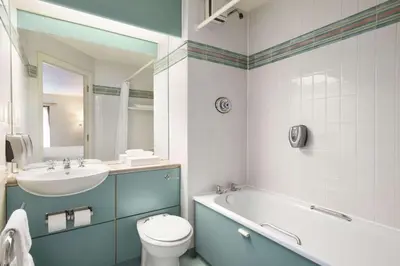 a bathroom with a sink and a tub and a toilet at Days Inn Lockerbie - Annandale Water in Johnstonebridge