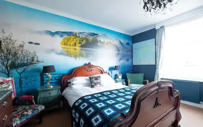a bedroom with a bed with a painting on the wall at The Mount self-catering in Portinscale