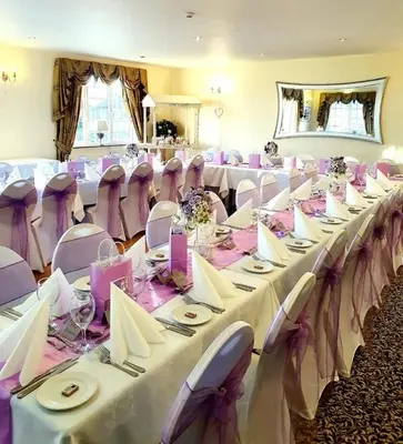 a room full of tables and chairs with white tablecloths at Solway Lodge Hotel in Gretna Green