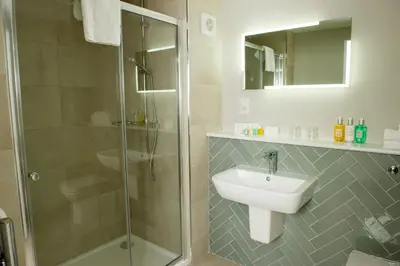a bathroom with a glass shower and a sink at Crown Hotel Wetheral in Carlisle